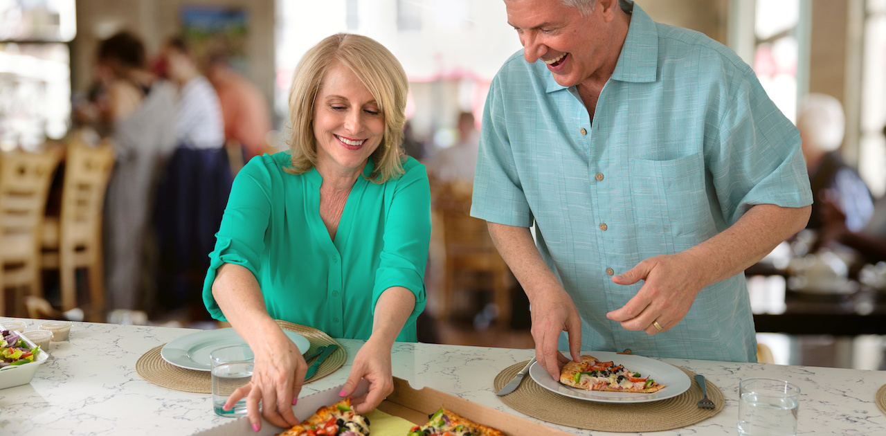 A man and woman eating Domino’s pizza during a game night.