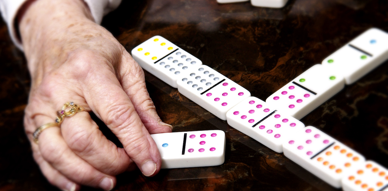 a senior playing mexican train dominoes